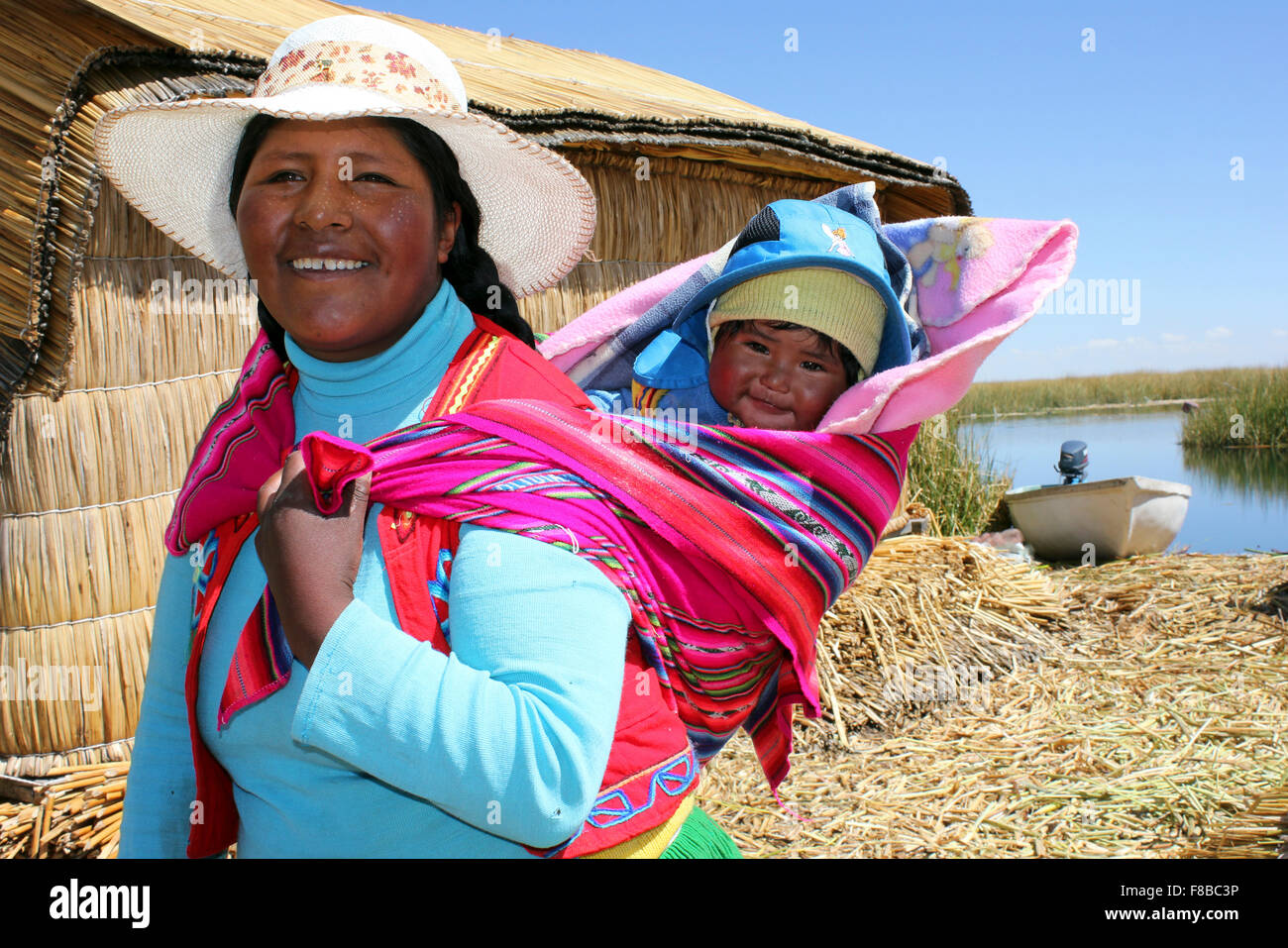 Indios Uros mujer y su bebé transportada en Papoose tradicional Foto de stock