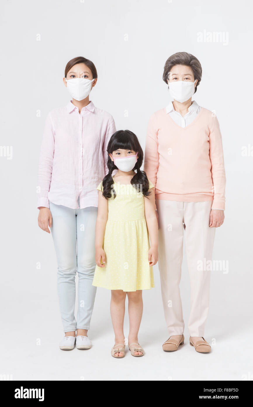 Joven, adulto joven mujer, y la mujer mayor de pie con sus máscaras en Foto de stock
