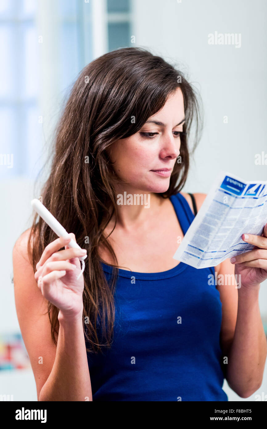 Adolescente leer la hoja de instrucciones de tampones. Foto de stock