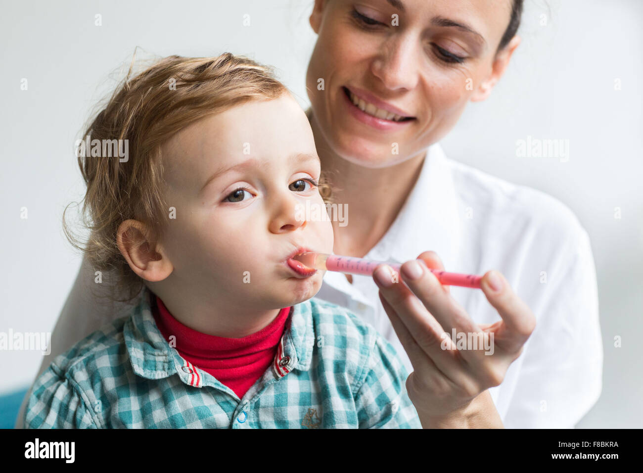2 años de edad tomando jarabe con una pipeta. Foto de stock