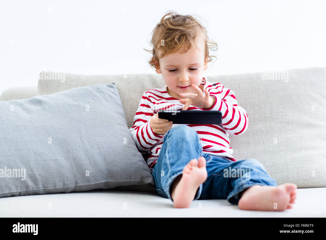 Niño de 2 años con teléfono celular. Foto de stock