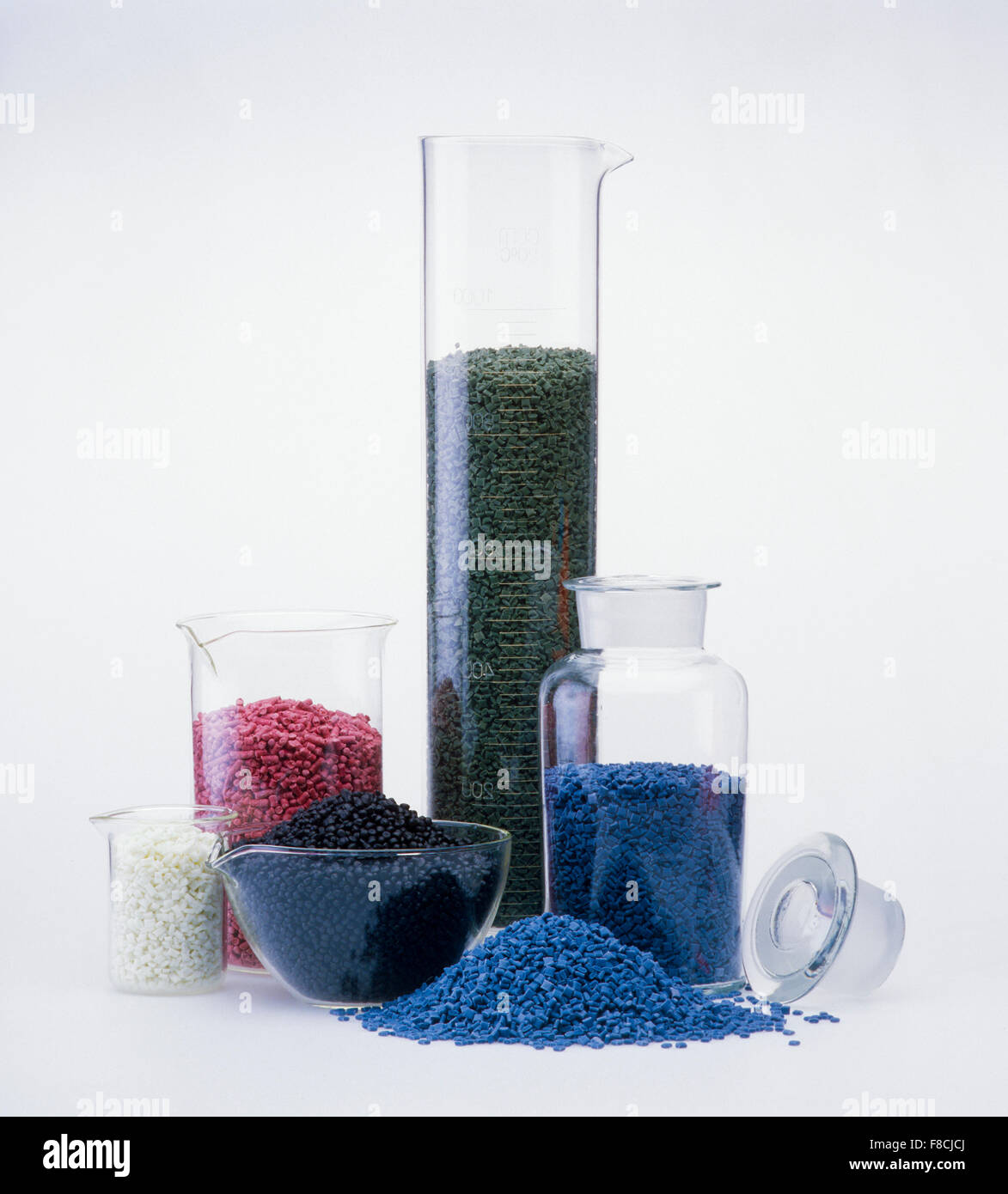 material plástico granulado en equipos químicos de vidrio en un departamento de investigación, aislado sobre blanco Foto de stock