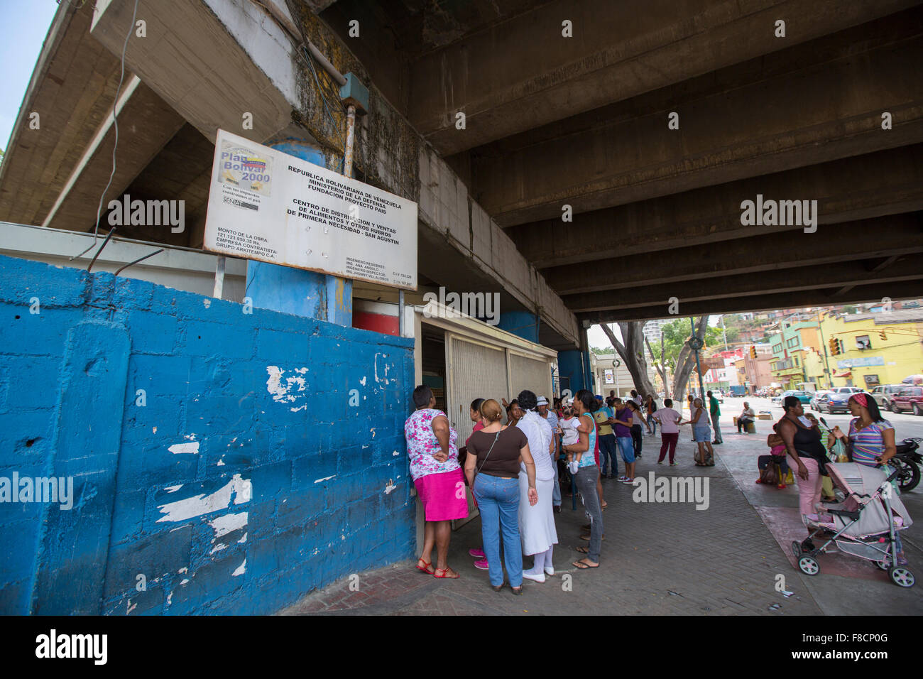 Grupo de personas esperando en línea en un supermercado público en Caracas. Foto de stock