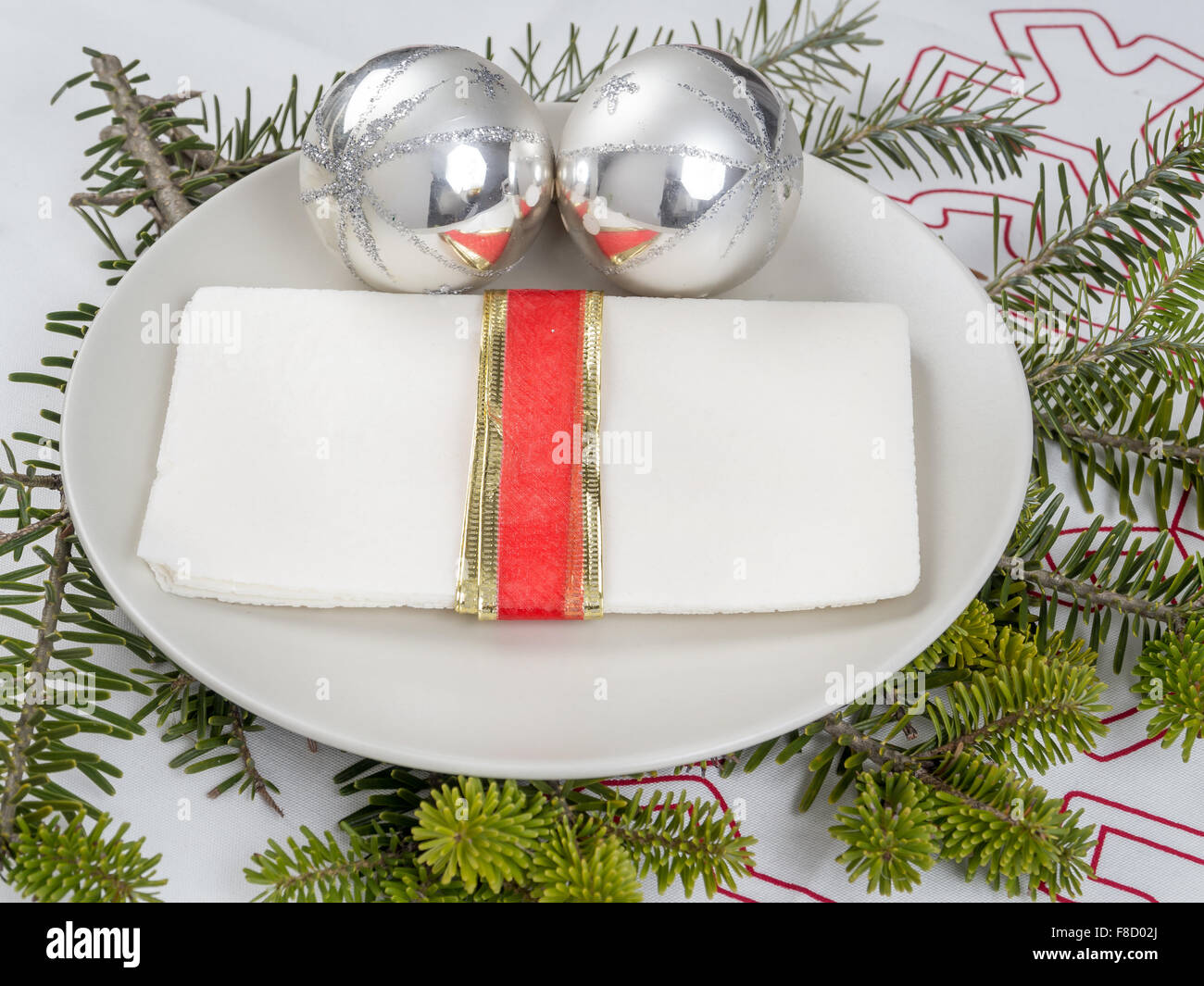 La víspera de Navidad tradicional oblea blanca en una placa de plata con bolas de navidad Foto de stock