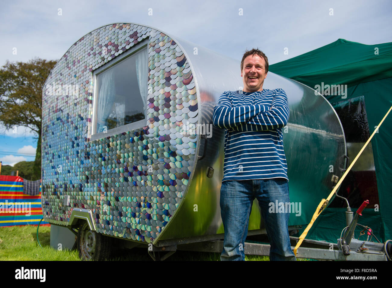 El artesano y el maker Carwyn Lloyd Jones, de pie fuera de su pequeña caravana con armazón de madera que él mismo hizo de madera de desecho rescatado y cubiertos en el exterior con discos compactos reciclados, Gales Aberystwyth UK Foto de stock