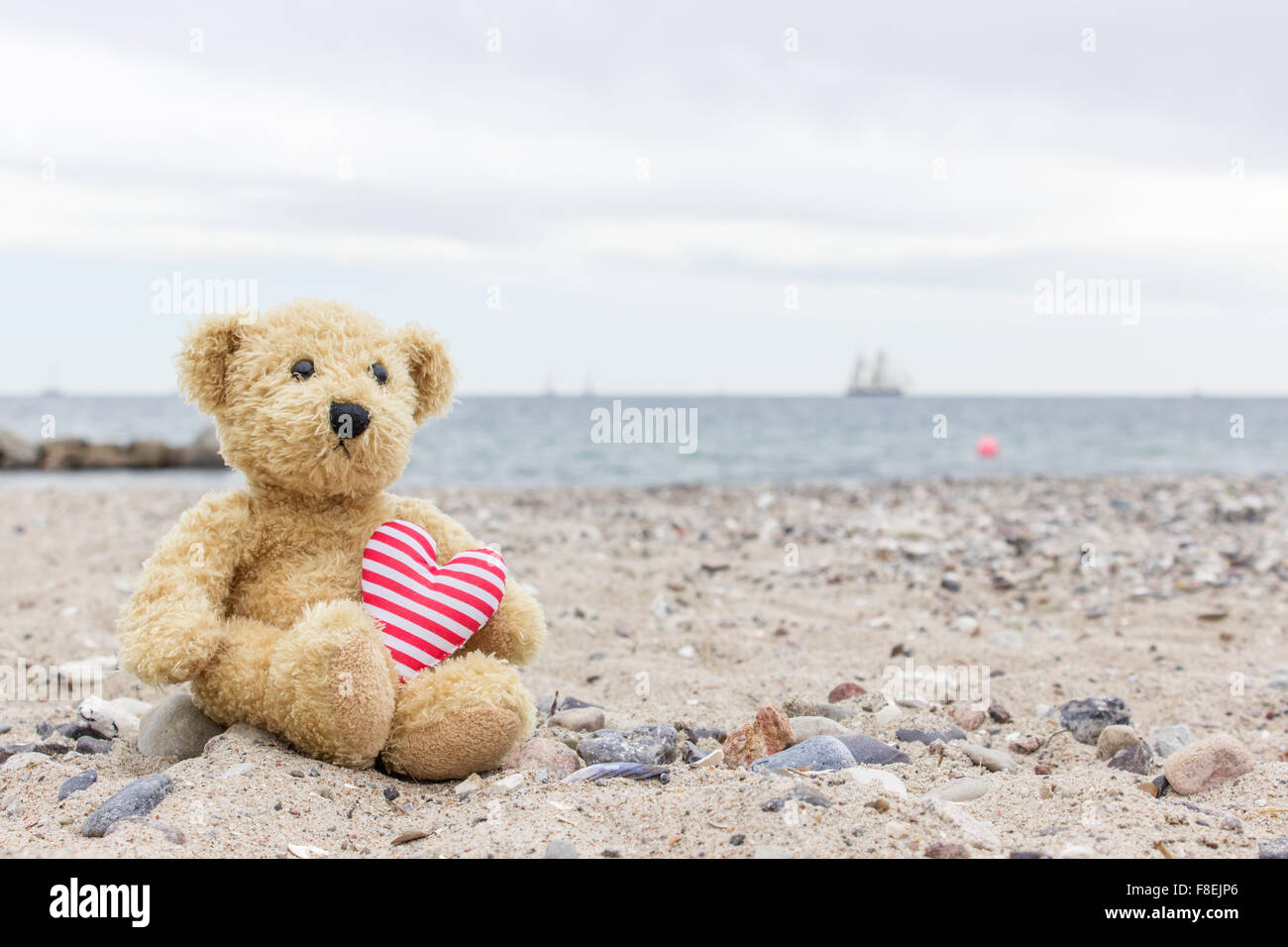Un oso de peluche con mi corazón se asienta en el Baltic Beach Foto de stock