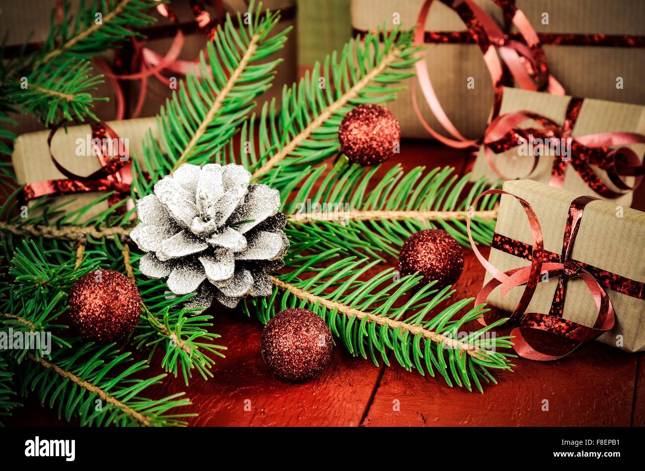 Artículos de decoración y regalos de Navidad. Árbol de Navidad, cono de pino, chucherías y regalos en el fondo. Profundidad de campo. Foto de stock