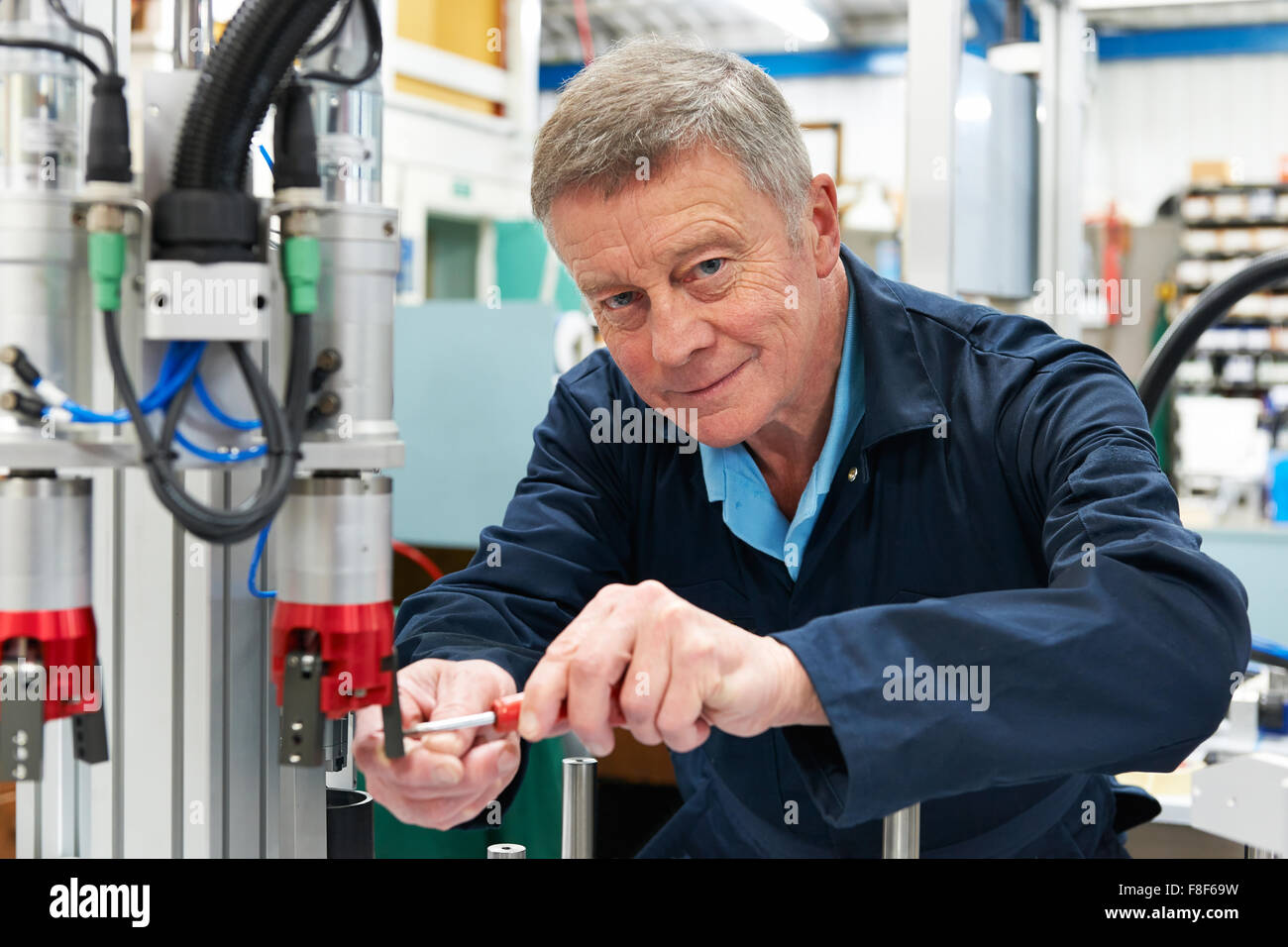 Ingeniero que trabaja en la máquina en la fábrica. Foto de stock