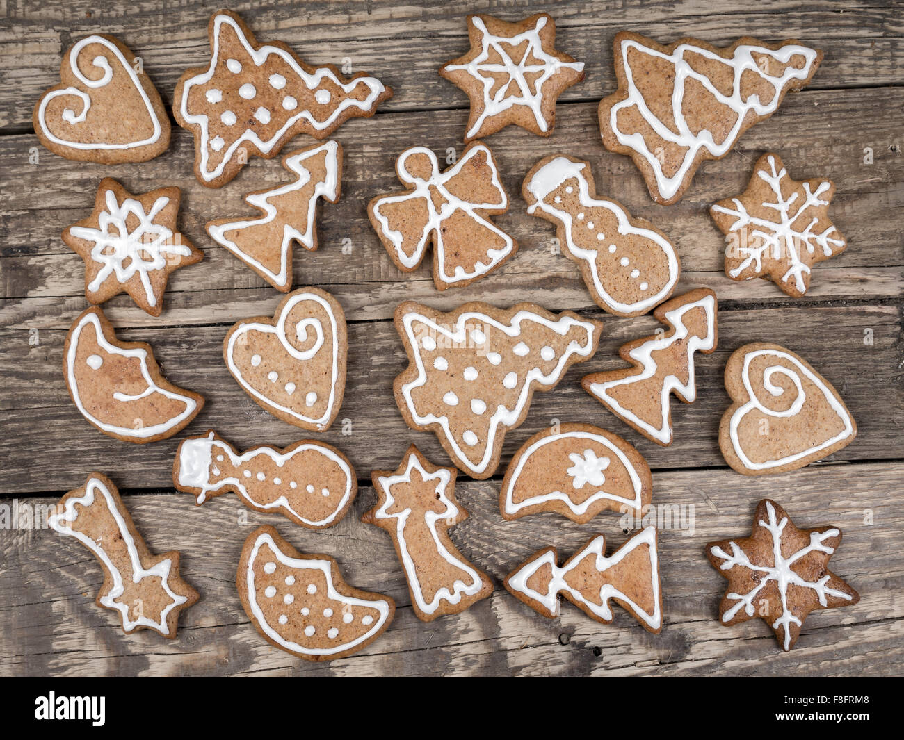 Diferentes formas de Navidad galletas de jengibre con blanco hielo colocado en placas rústico de madera Foto de stock