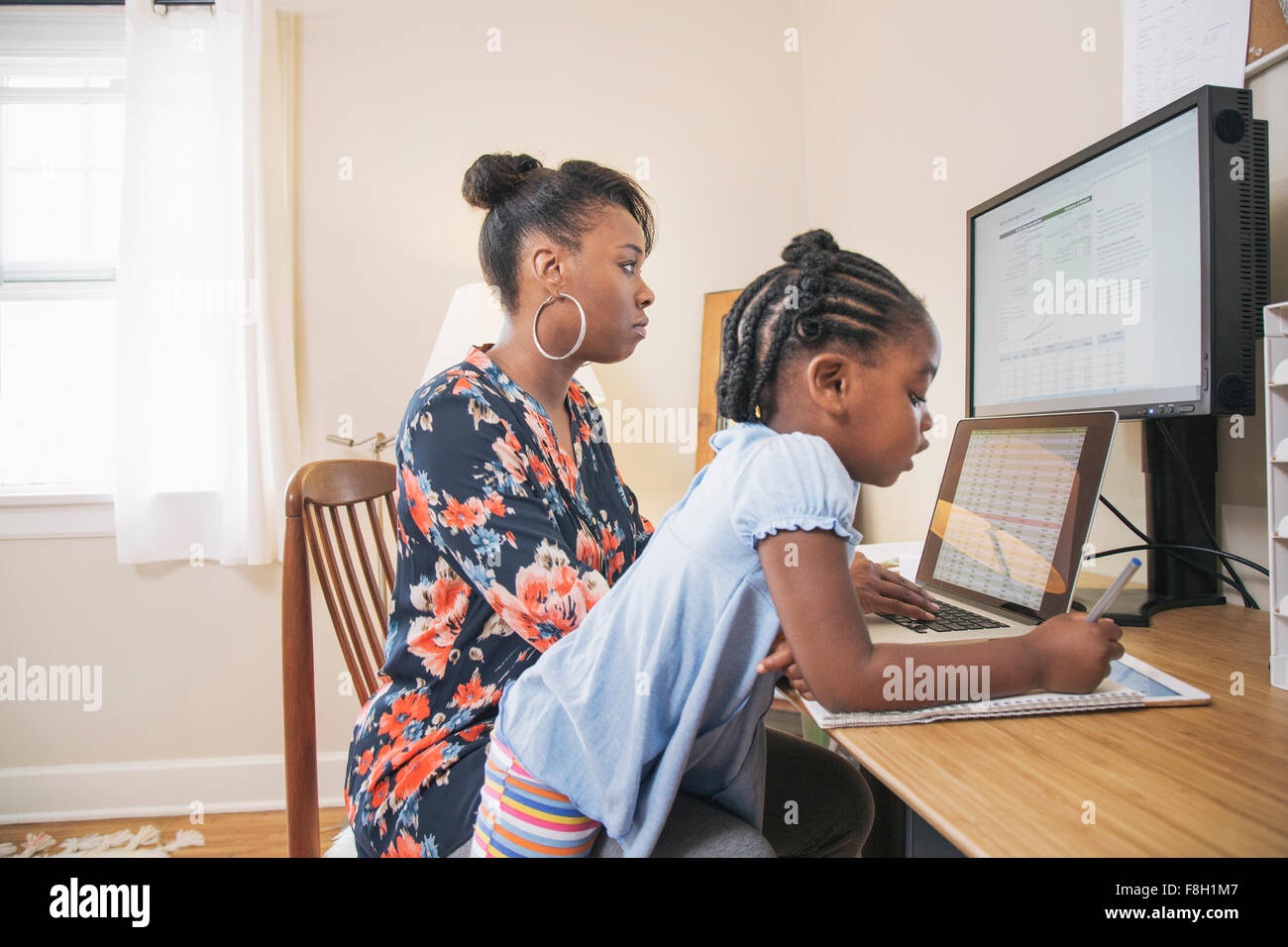 Madre africano-americanos con la hija trabaja desde casa Foto de stock