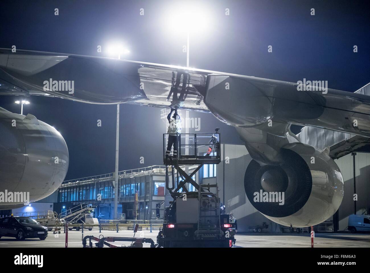 Miembro de la tripulación de tierra el repostaje de aviones A380 en la noche Foto de stock