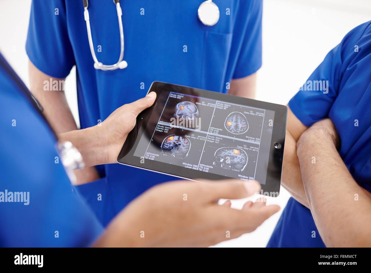 Los médicos mirando las exploraciones en tableta digital Foto de stock