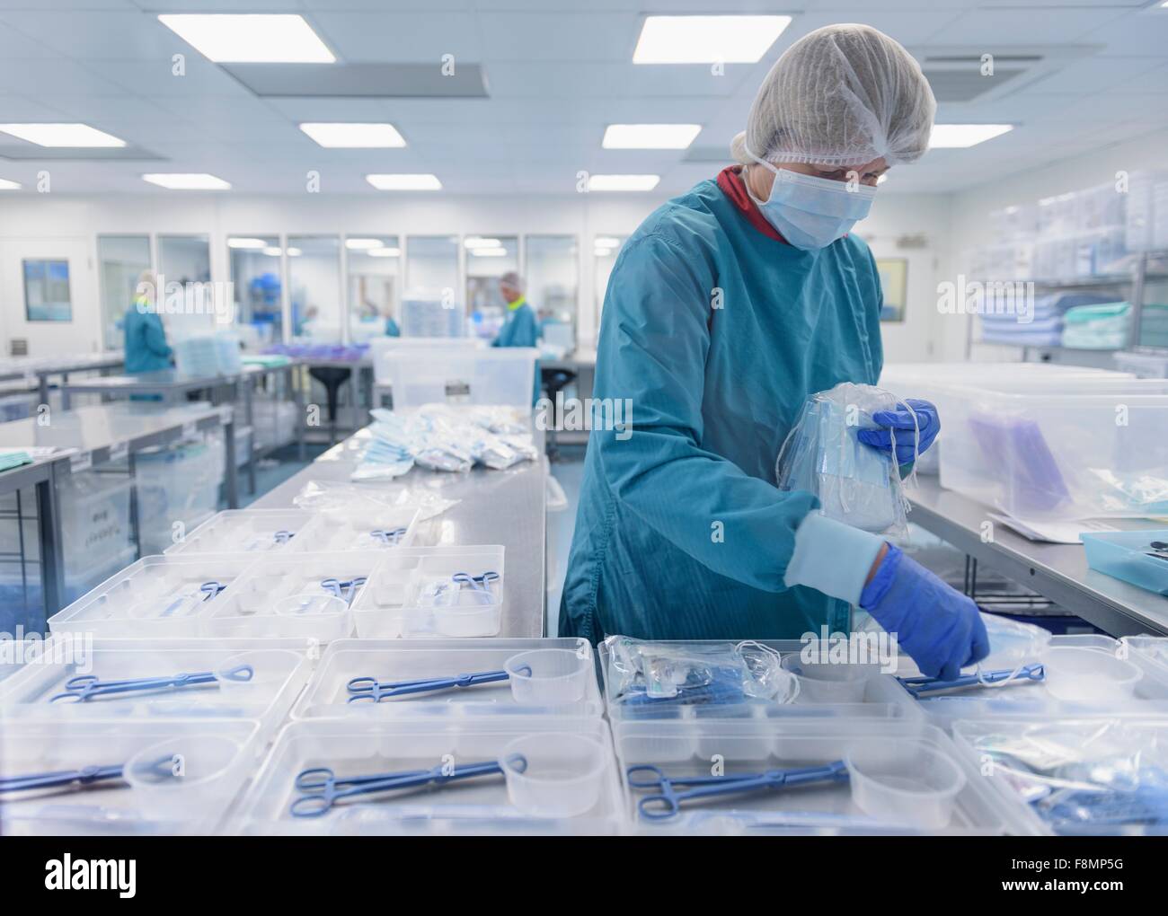 Embalaje trabajador instrumental quirúrgico en sala limpia de fábrica de instrumentos quirúrgicos Foto de stock