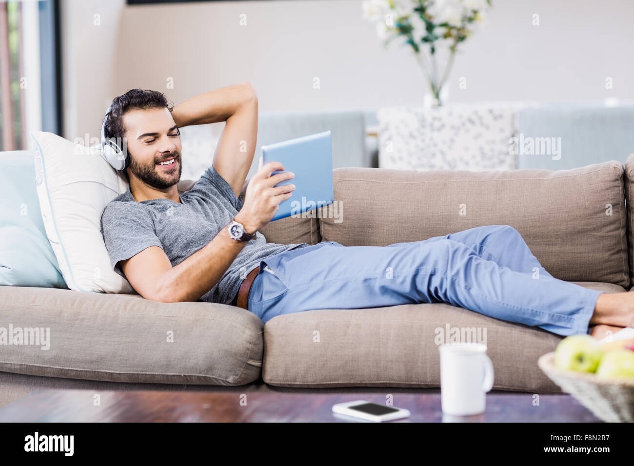 Guapo con tablet y de auriculares. Foto de stock