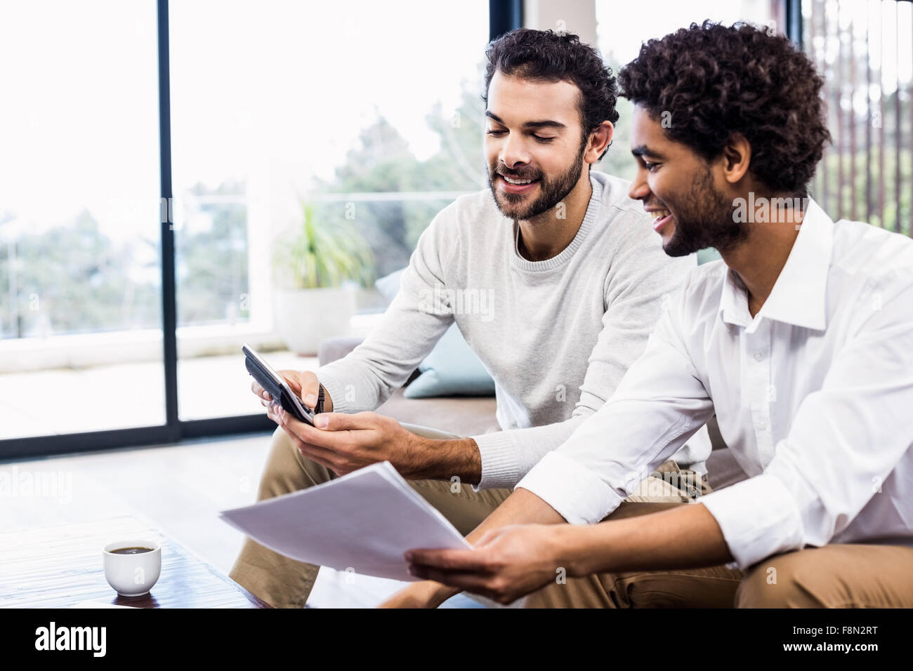 Sonriente pareja gay pagar facturas Foto de stock