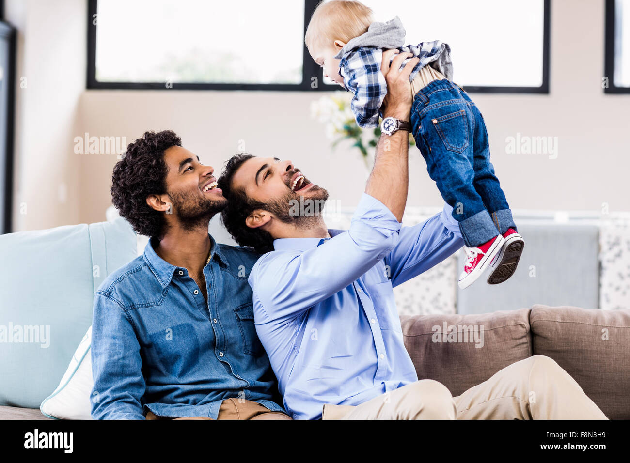 Feliz pareja gay jugando con niños Foto de stock