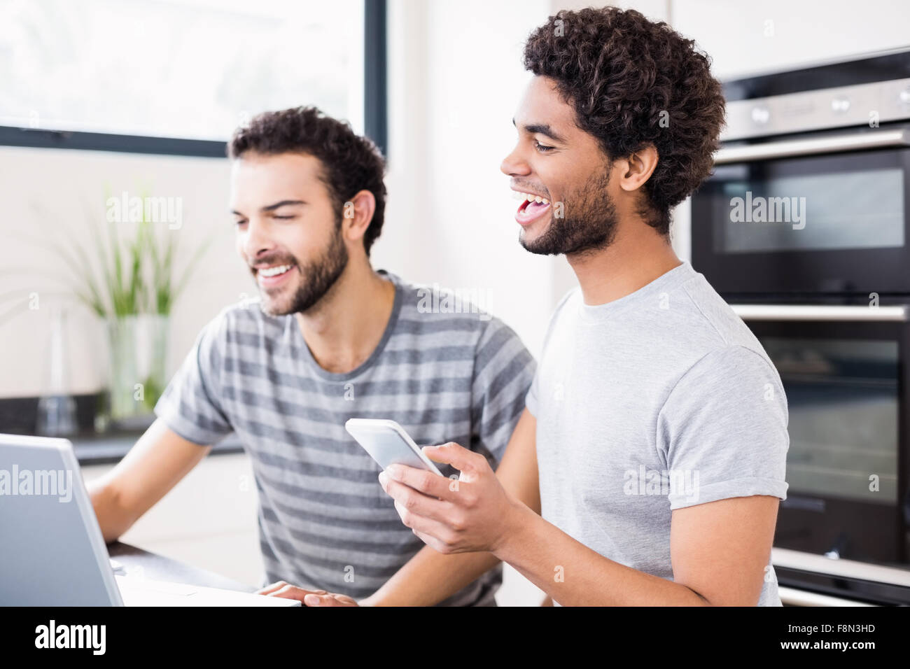 Feliz pareja gay usando tecnología Foto de stock