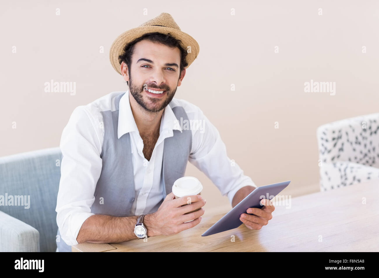 Retrato del hombre sonriente Celebración de tabletas y copa desechable Foto de stock