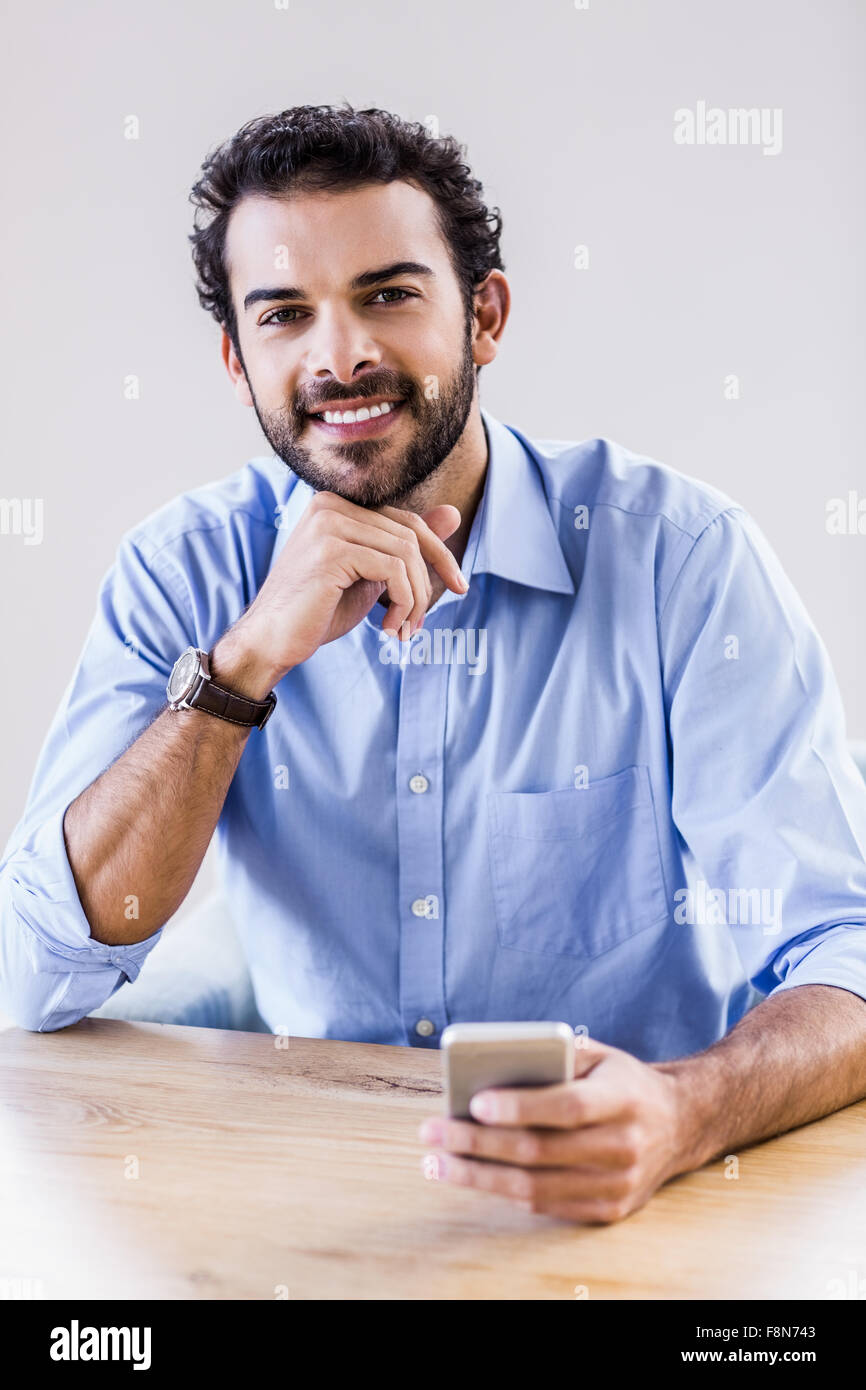 Hombre sonriente utilizando el smartphone Foto de stock