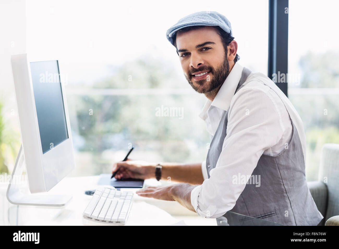 Guapo trabajando sonriente en la cámara Foto de stock