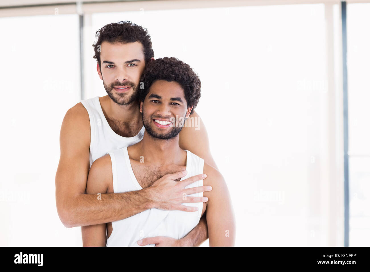 Una pareja gay sonriente abrazando Foto de stock