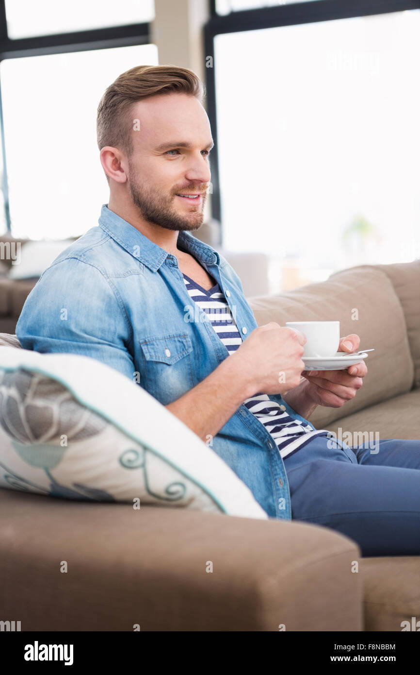 Hombre casual beber té en el sofá Foto de stock