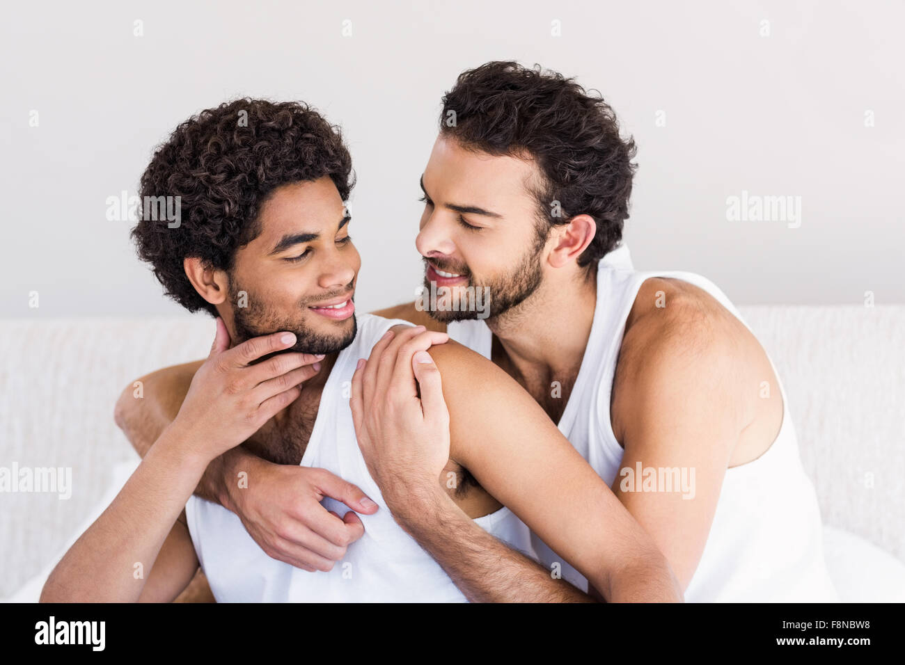 Sonriente pareja gay en la cama Fotografía de stock - Alamy