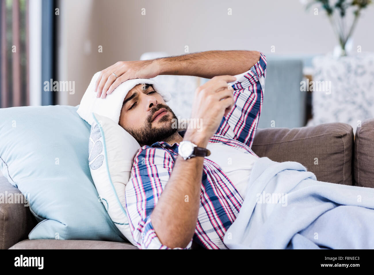 Hombre enfermo comprobar la temperatura Foto de stock