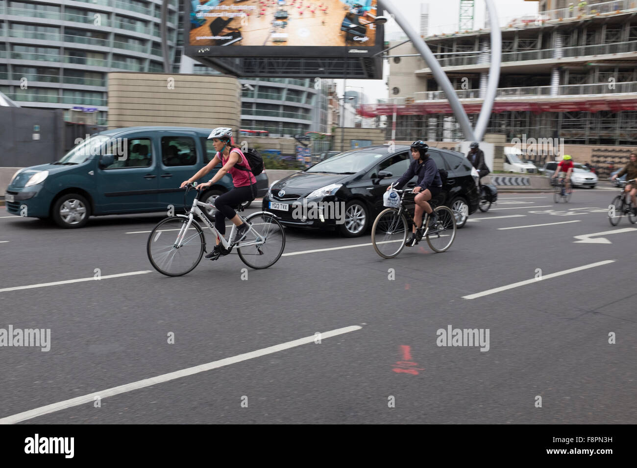 Los ciclistas la aceleración en la concurrida carretera de Londres,Old Street,Rotonda,Londres,Inglaterra Foto de stock