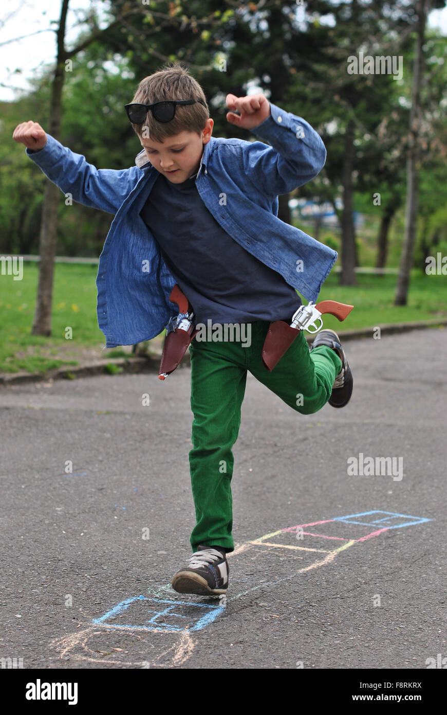 Niño jugando rayuela en la calle Foto de stock