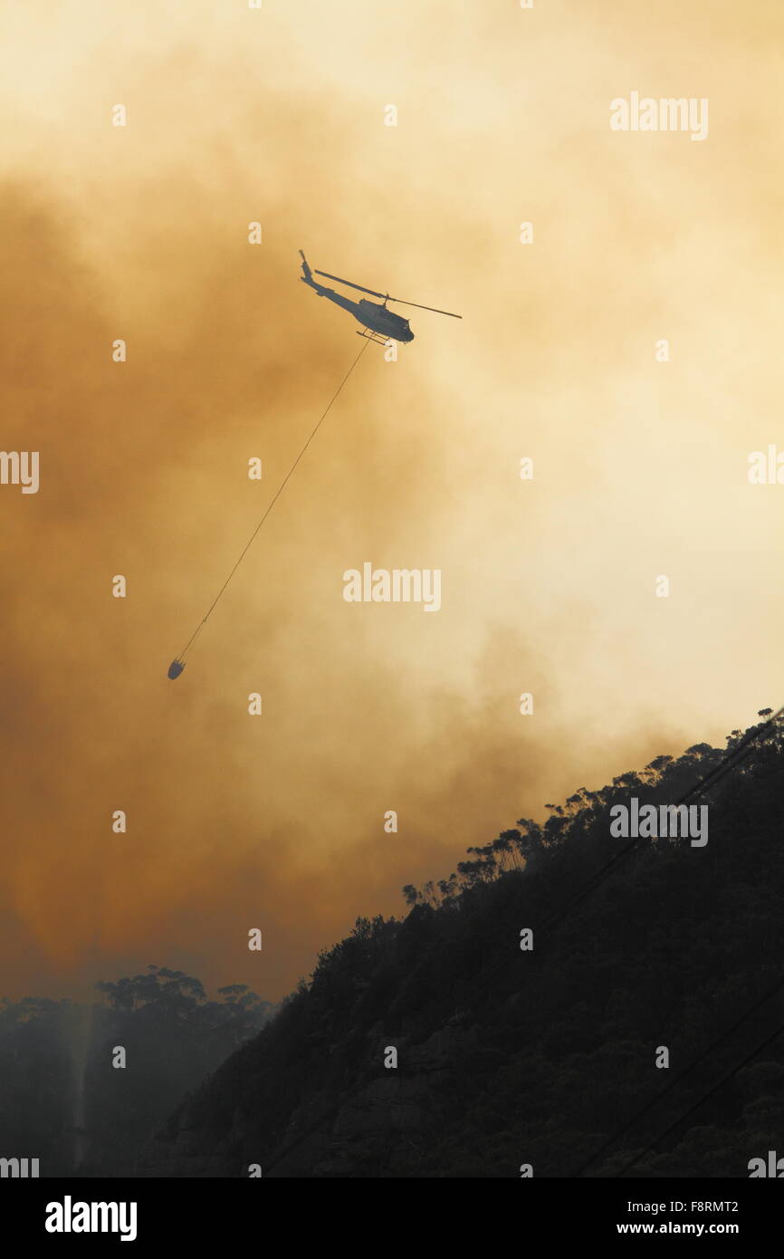 Escarpe Illawarra, NSW, Australia. 11 dic, 2015. El agua-bombardeo helicóptero Combatiendo los incendios en Maddens llanos en la escarpa de Illawarra, NSW, Australia. Crédito: Andrew McInnes/Alamy Live News Foto de stock