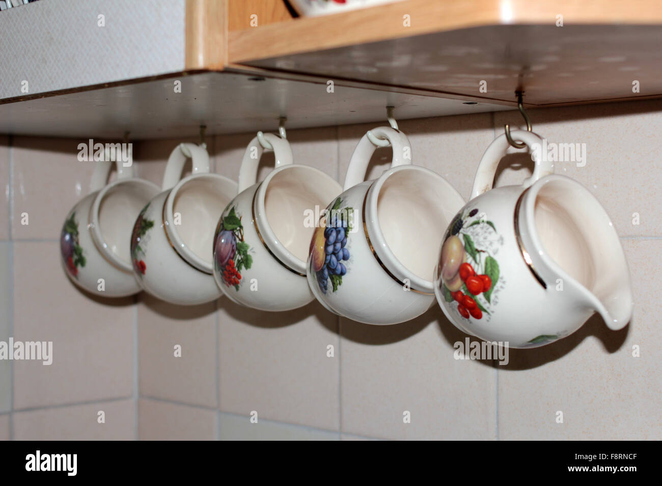 Tazas decorativas colgantes y la jarra de leche Fotografía de stock - Alamy