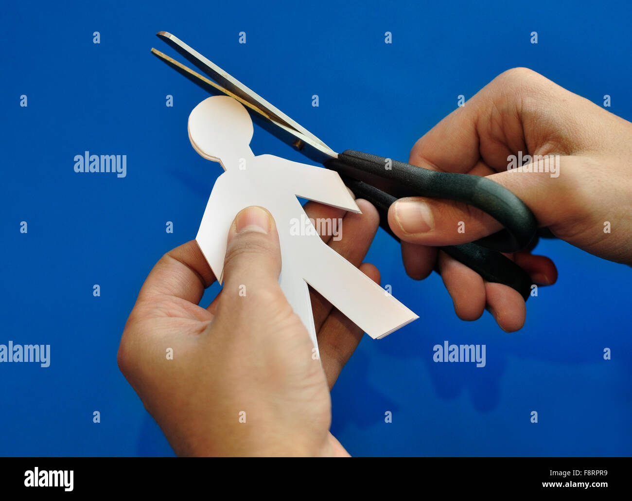 Corte de papel 'personas'. Fomentar el talento - un concepto. Primer plano de una mano con la tijera de corte de papel ilustración. Foto de stock