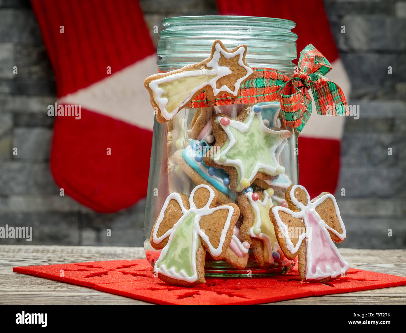 Assorted Christmas gingerbread cookies con coloridos guinda en tarro de cristal en la mesa Foto de stock