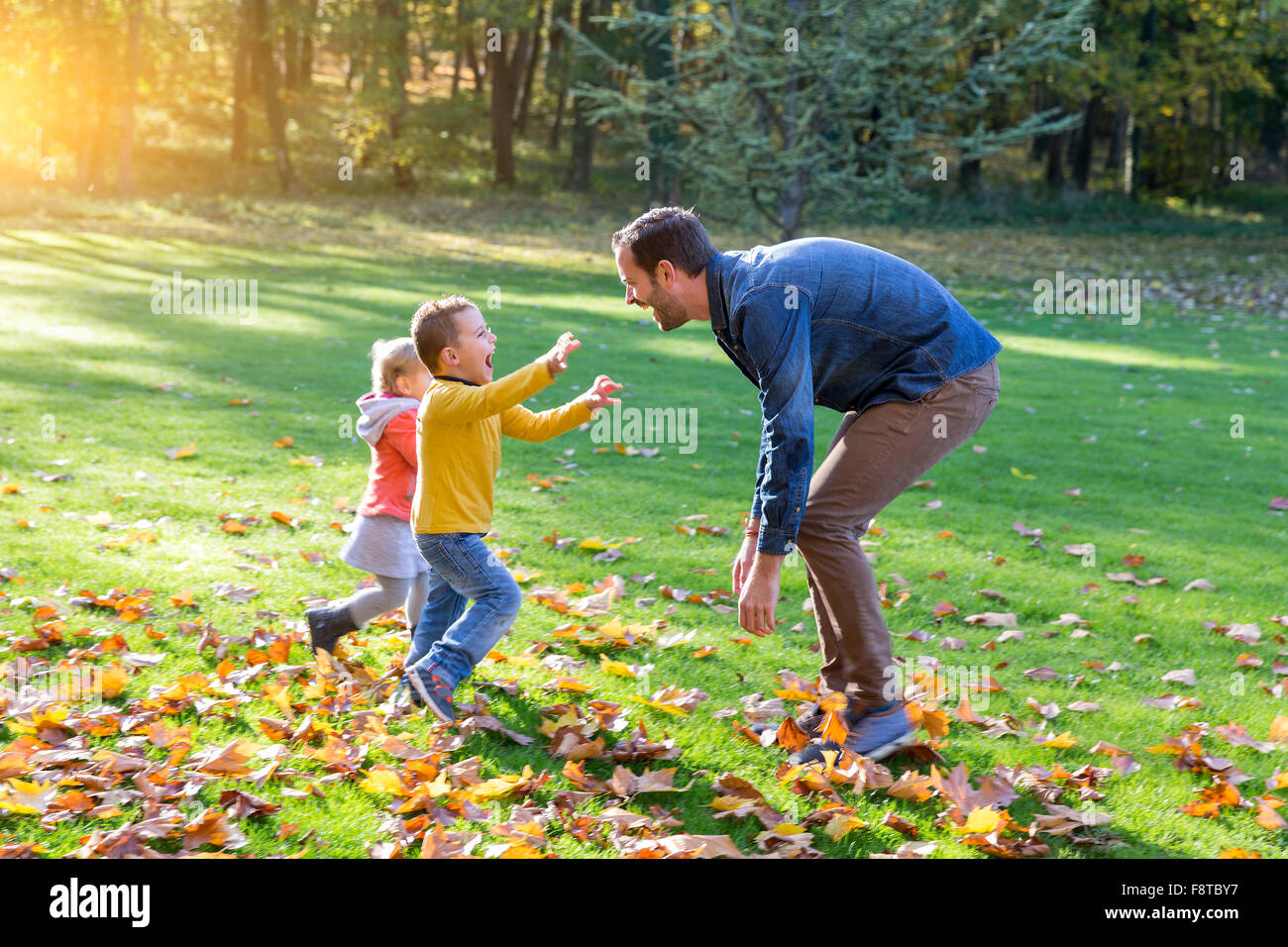 Padre con sus hijos jugando en el parque Foto de stock
