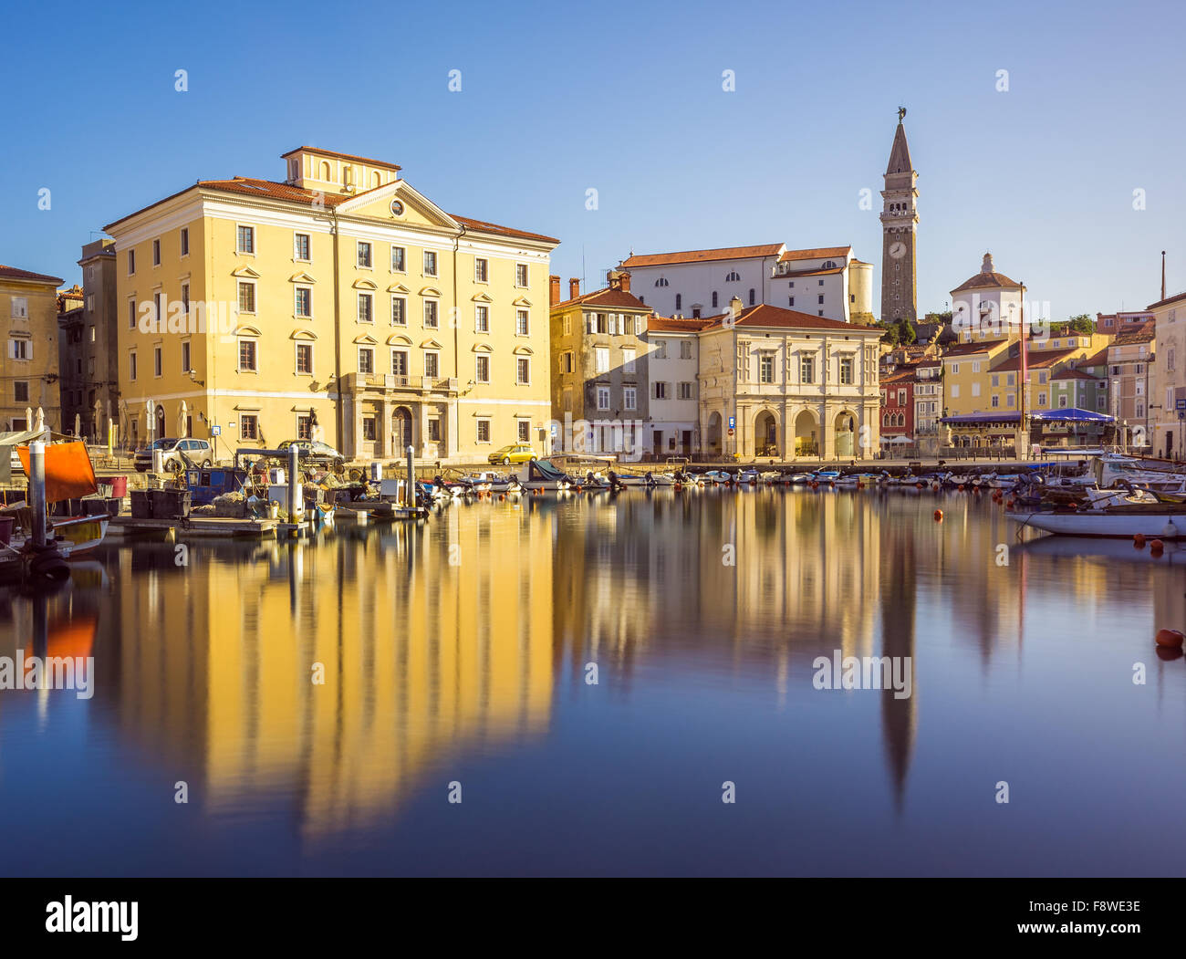 Edificios de la plaza principal de Tartini Piran ciudad reflejada en el agua en Eslovenia. Foto de stock