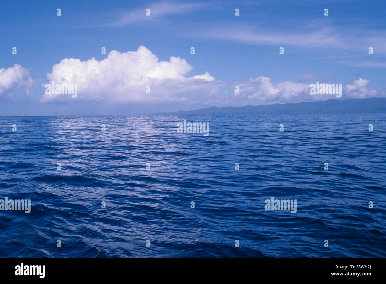 Mar en calma, azul océano, cielo azul opiniones de Islas Palau con formaciones nubosas. Foto de stock