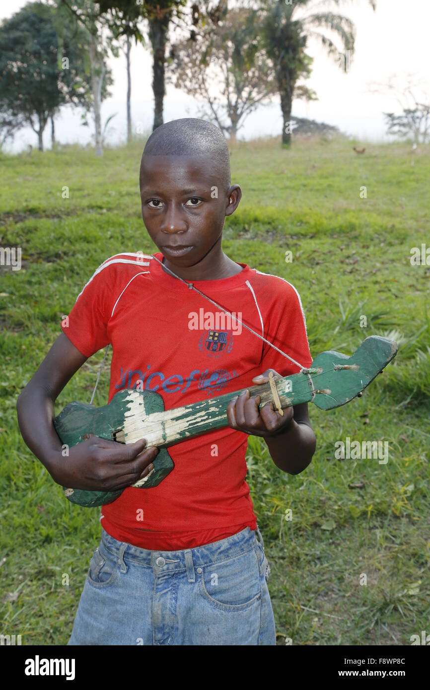 Niño jugando en una casa construida, Matamba-Solo de guitarra, en la provincia de Bandundu, Congo-Brazzaville Foto de stock