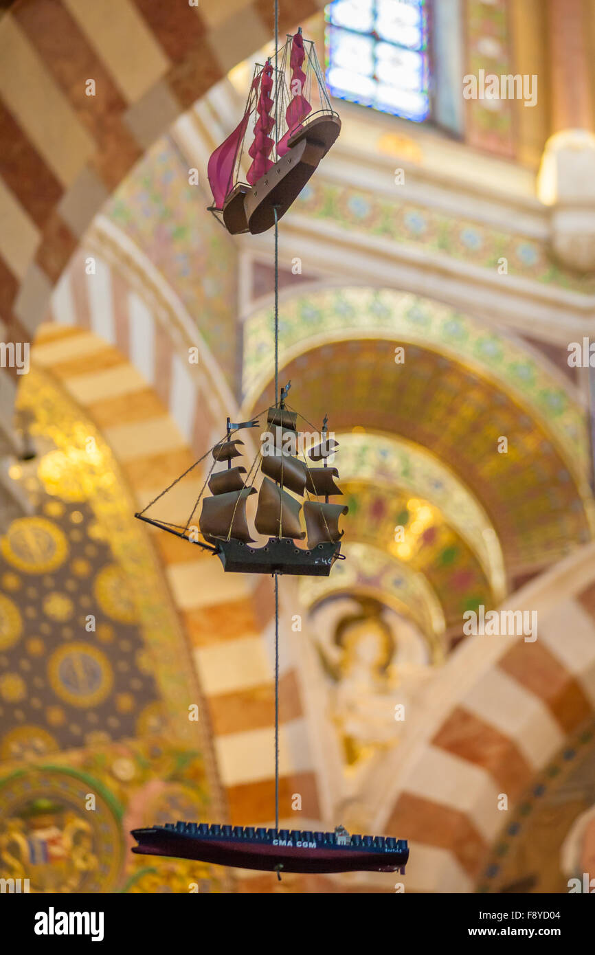 Modelos de barcos colgando del techo interior de la catedral de Notre Dame de la Garde, Marsella, Francia Foto de stock