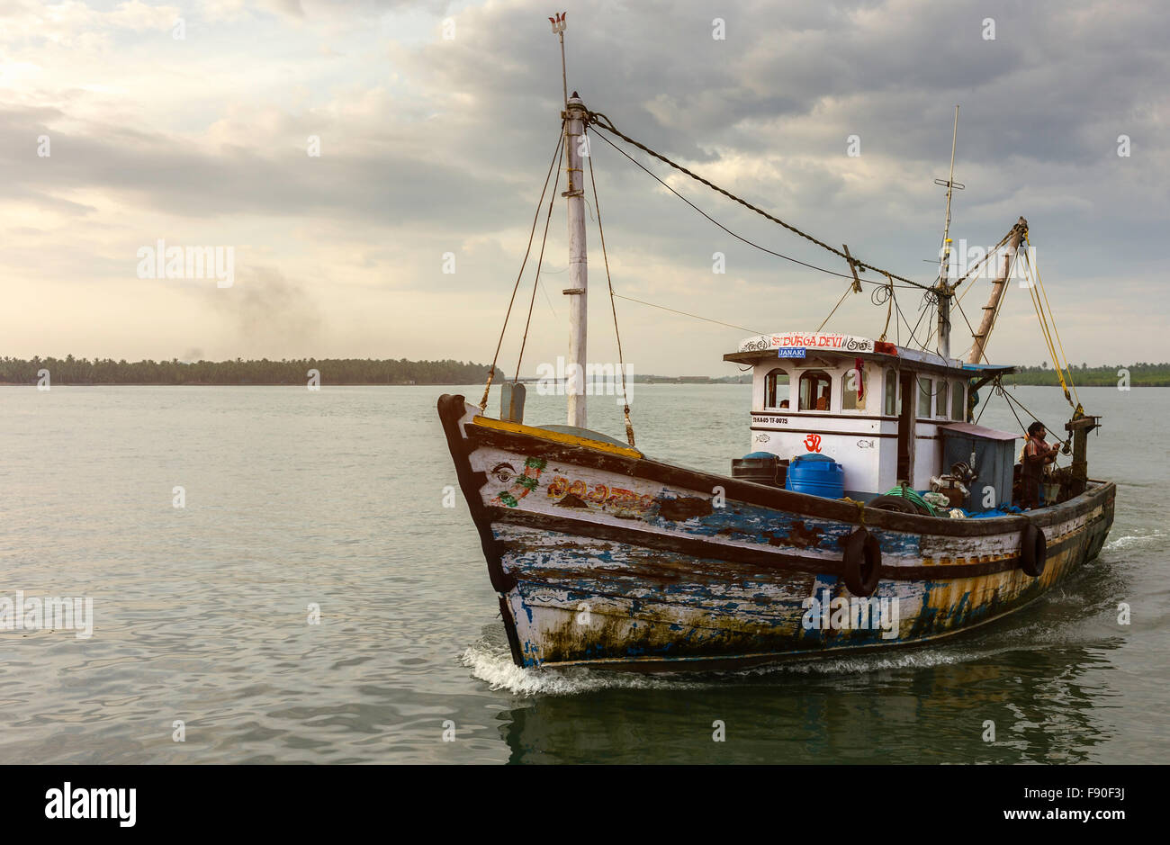Arrastrero devuelve al atardecer desde el mar profundo viaje de pesca en el Mar de Arabia y el ancla en puerto Valapattam, Kerala, India. Foto de stock