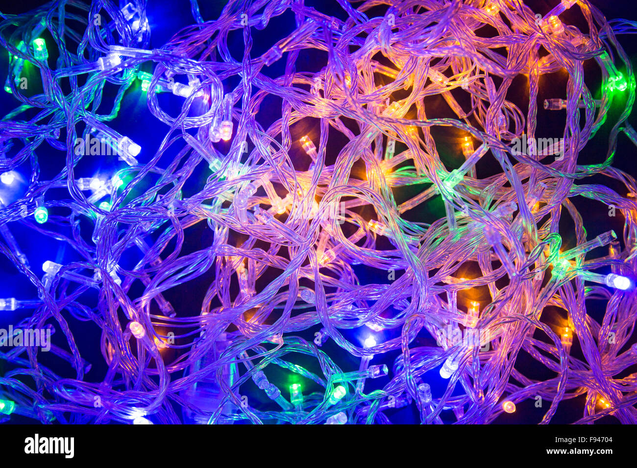 Las luces de Navidad de colores el caos de cables con fondo negro Foto de stock