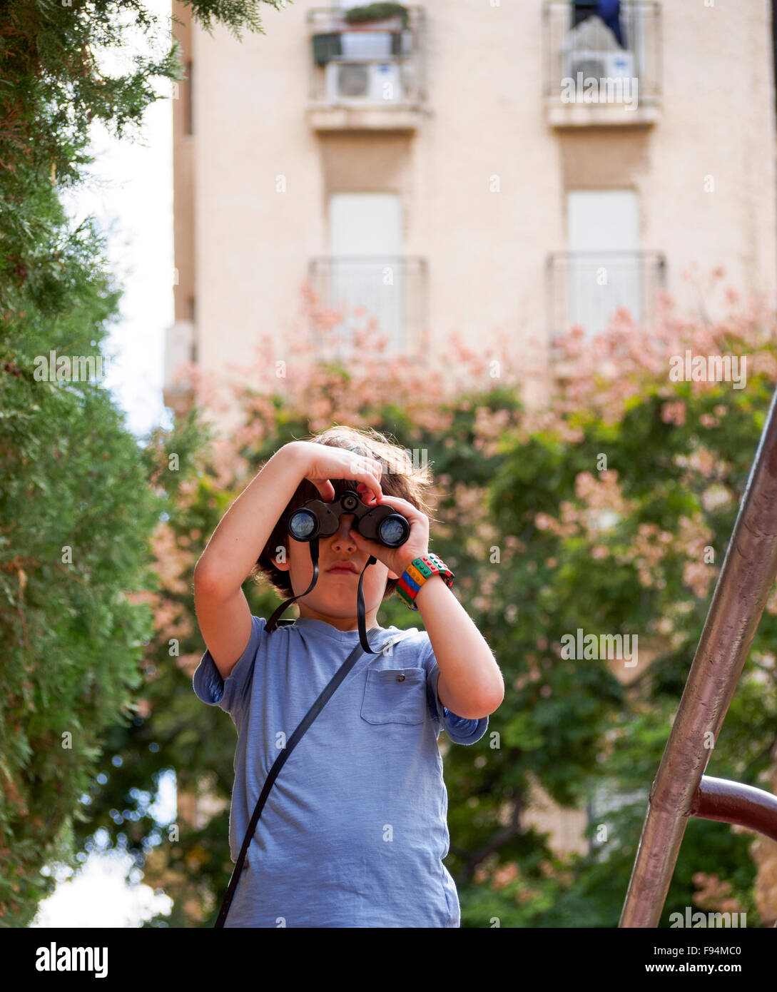 Birdwatcher joven un chico de siete años con prismáticos Foto de stock