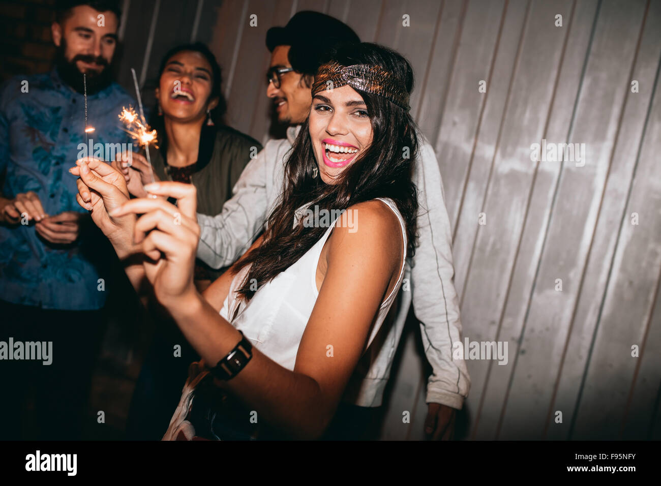 Foto de una chica jugando con estrellitas en la noche. Mejores amigos celebrando el 4º de julio afuera. Foto de stock