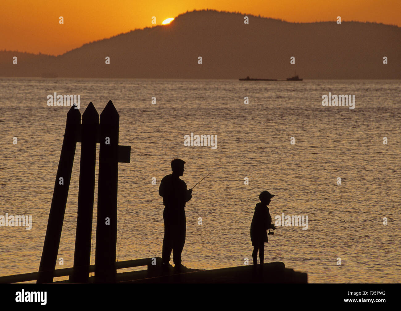 Silouettes de gente pescando al atardecer, las Islas de San Juan, WA Foto de stock