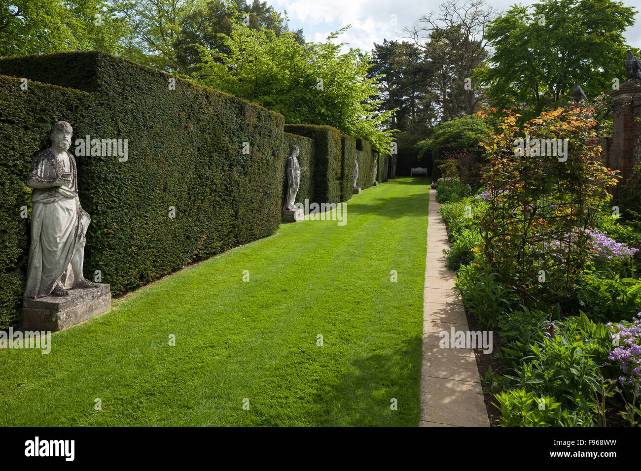 Bordes florales contemporáneo diseñado por Arne Maynard junto a estatuas clásicas por Scheemaker en Cottesbrooke Hall Gardens, Northamptonshire, Inglaterra. Foto de stock