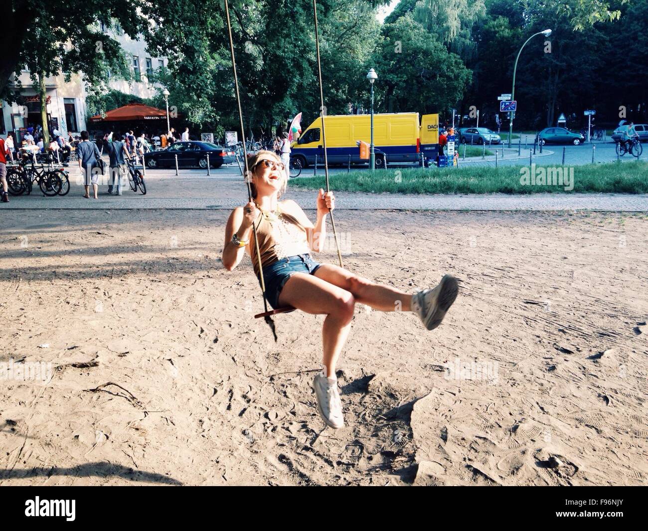 Longitud total de una linda chica sentada en Swing Foto de stock