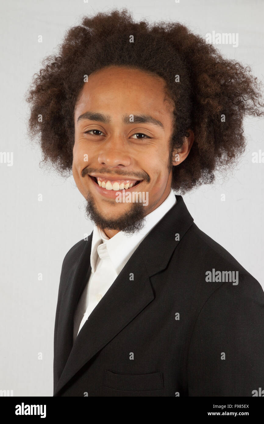 Hombre negro guapo en traje chaqueta con una sonrisa complacida Foto de stock