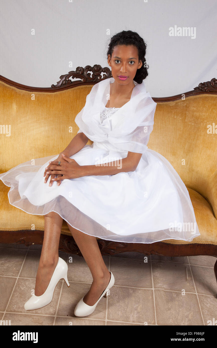 Bonita mujer negra en un tipo de vestido de boda blanco, mirando pensativo Foto de stock