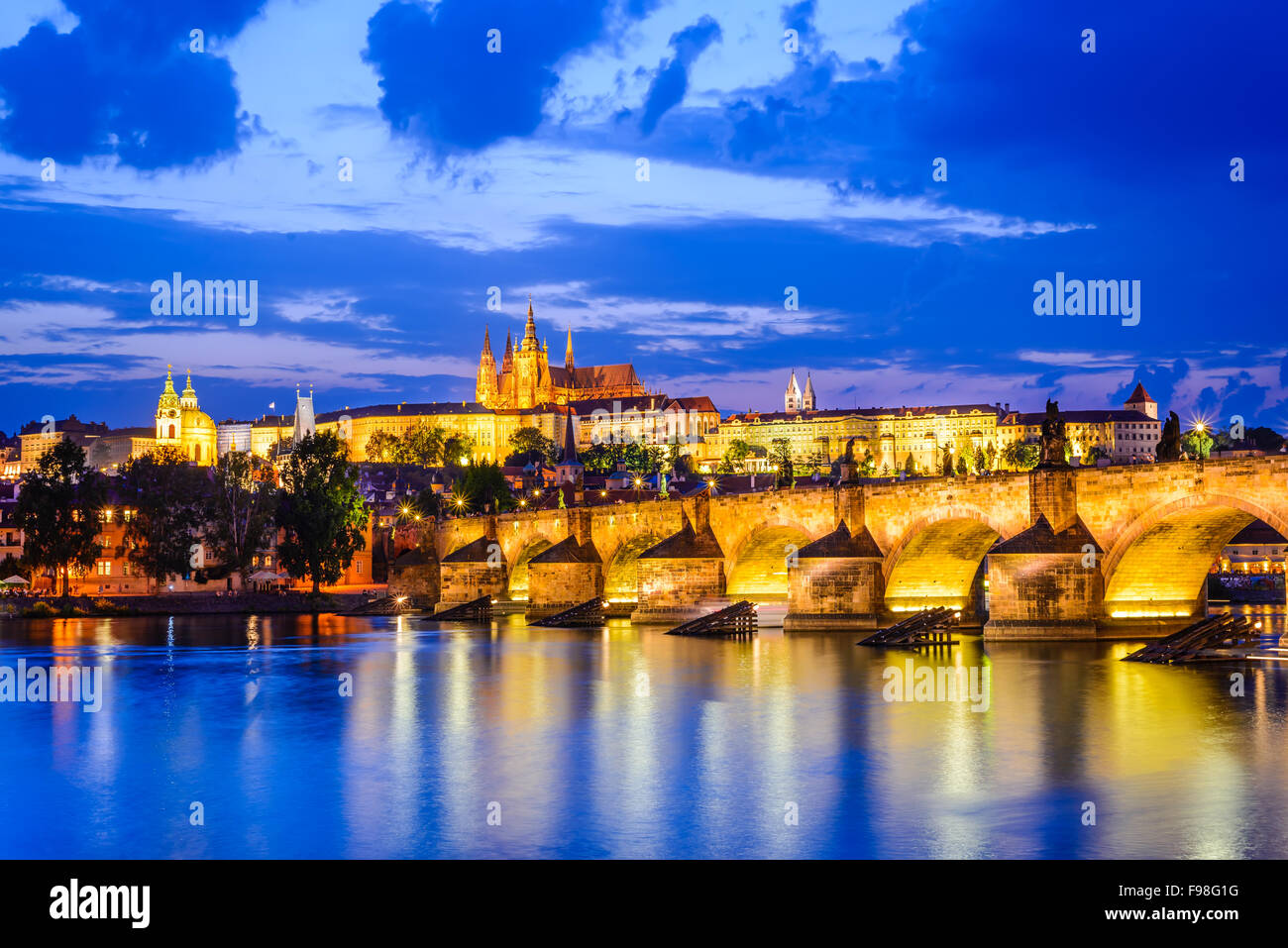 Praga, República Checa. Charles Bridge y Hradcany (Castillo de Praga) con la Catedral de San Vito y San Jorge iglesia tarde al anochecer, Foto de stock
