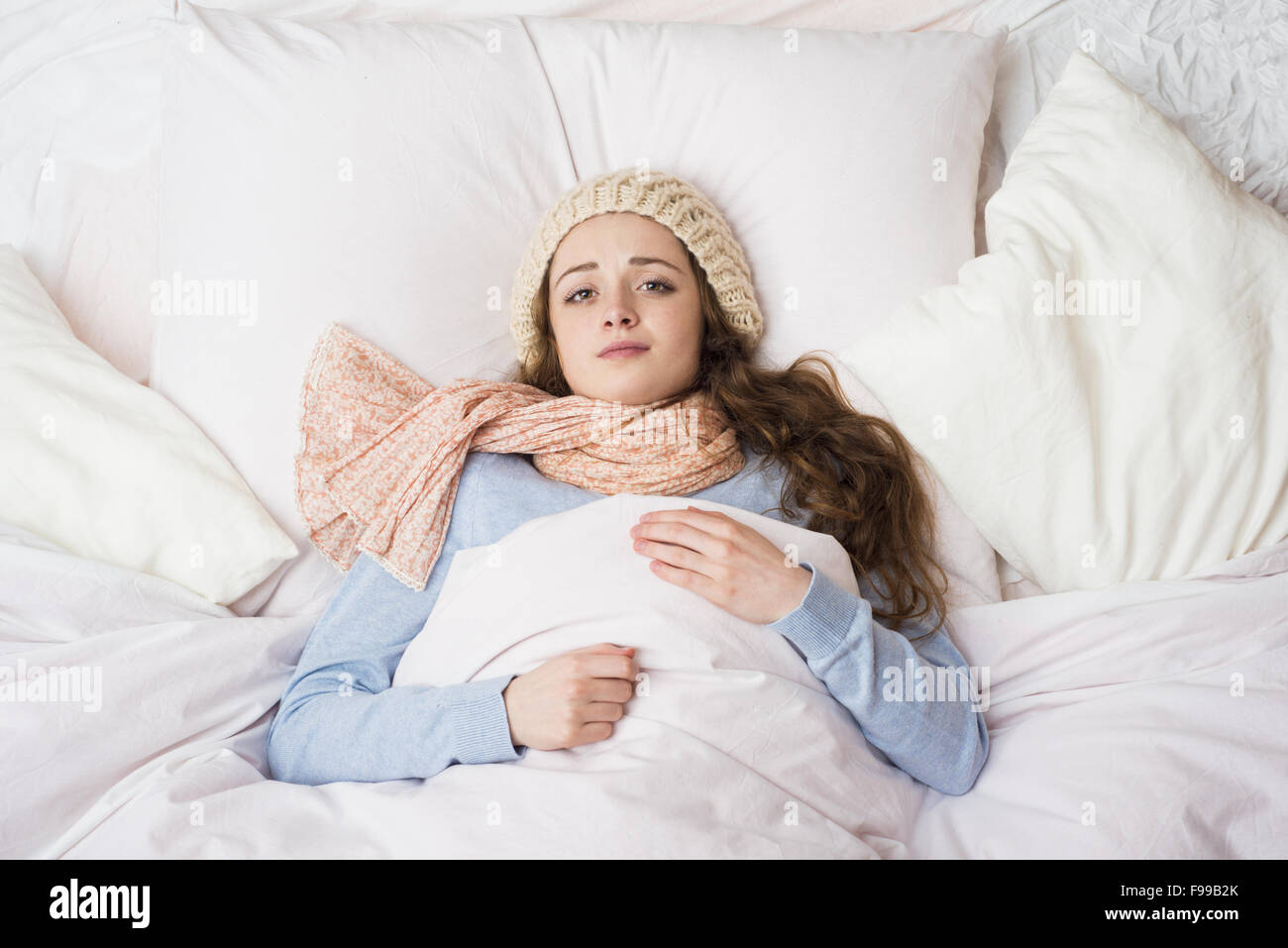 Mujer enferma acostado en la cama con fiebre alta. Ella tiene el resfriado y la gripe. Foto de stock